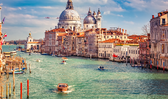 A serene, hidden canal in Secret Venice, surrounded by historic buildings and vibrant greenery.